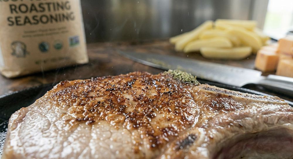 Close-up of browning on a protein surface in a hot pan showing the Maillard reaction creating the golden-brown crust